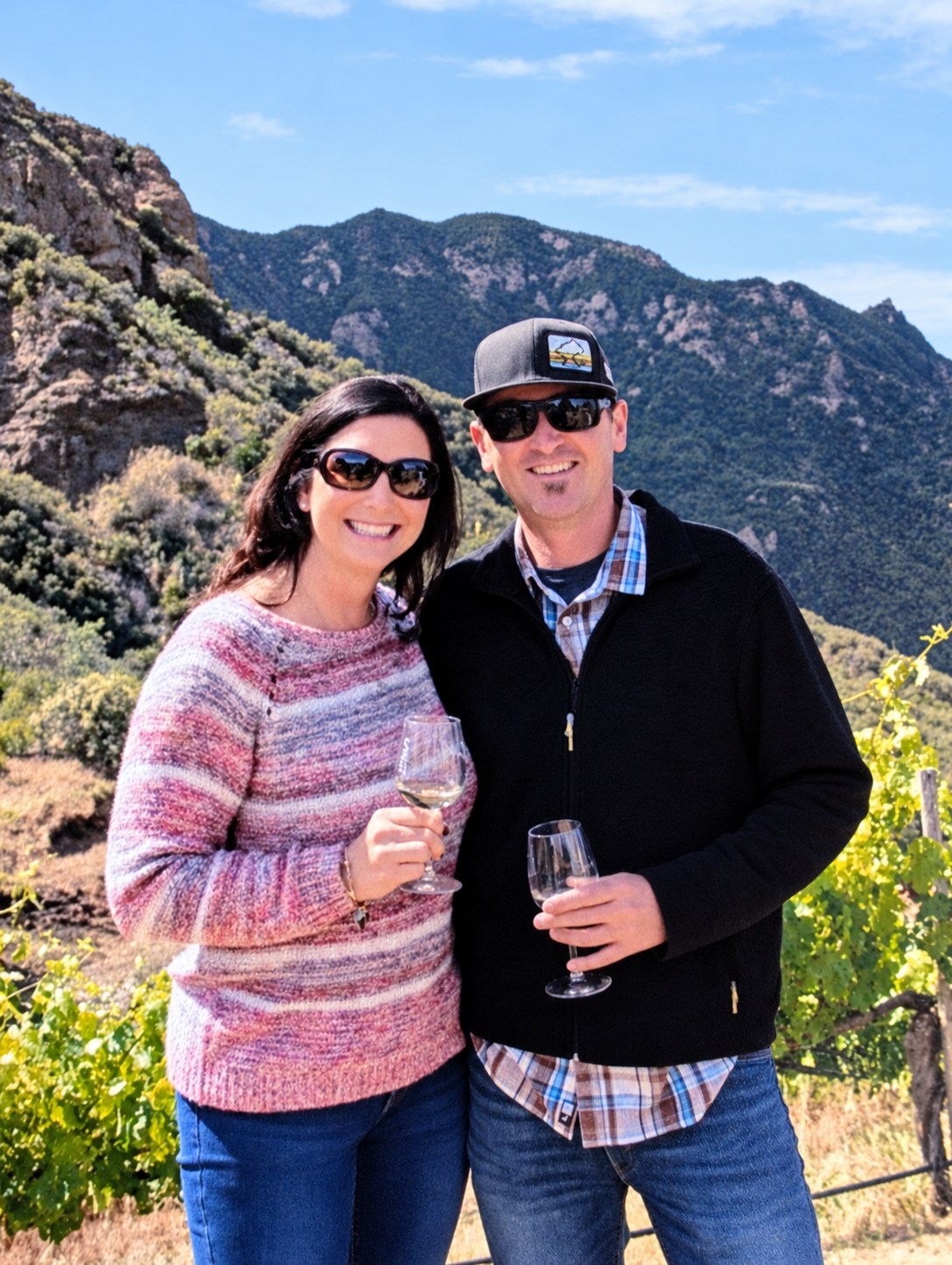 Ed and Melissa smiling together outdoors in the mountains